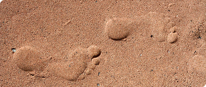 Bild av fotspår i sanden.